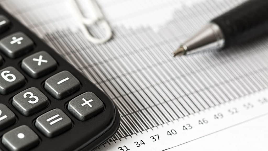 Calculator and pen on a printed financial report.